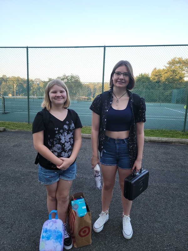 two girls standing at tennis courts