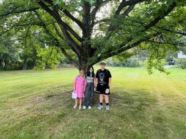 two girls and boy under large tree